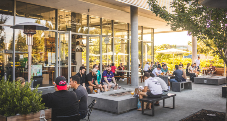 Guests enjoying beers by the fire pits outside at the San Ramon taproom